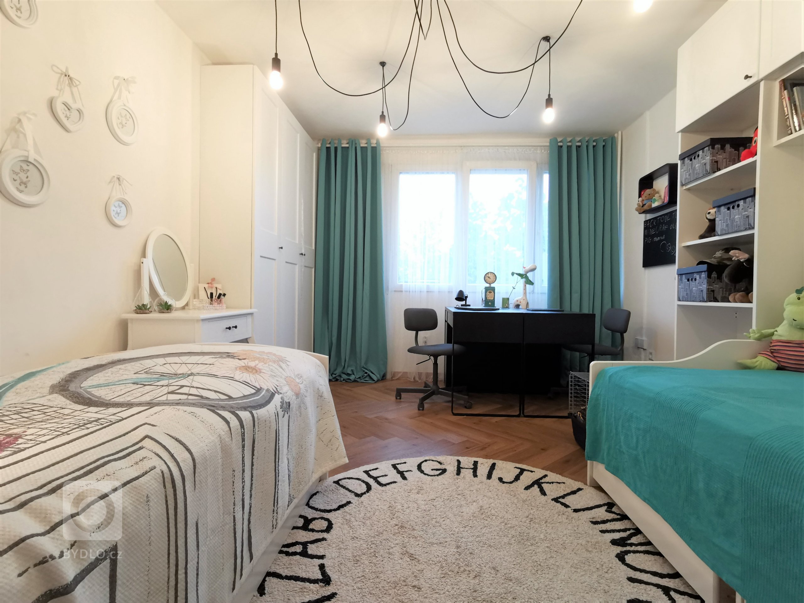 Třináctimetrový dětský pokoj také schovává spoustu vychytávek. Je dokonalou kombinaci nábytku koupeného v obchodech a vyrobeného na míru. Poličky u postelí nahrazují noční stolky, na které prostě nezbyl prostor. Šikovně navržená knihovna zase schovává mohutný králičí domeček.  