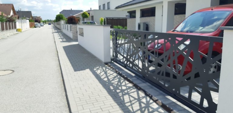 Realizované oplocení nového rodinného domu. Výška plotových dílců koresponduje se šířkou oken domu v pozadí. Moderní design však strhává pozornost více na…