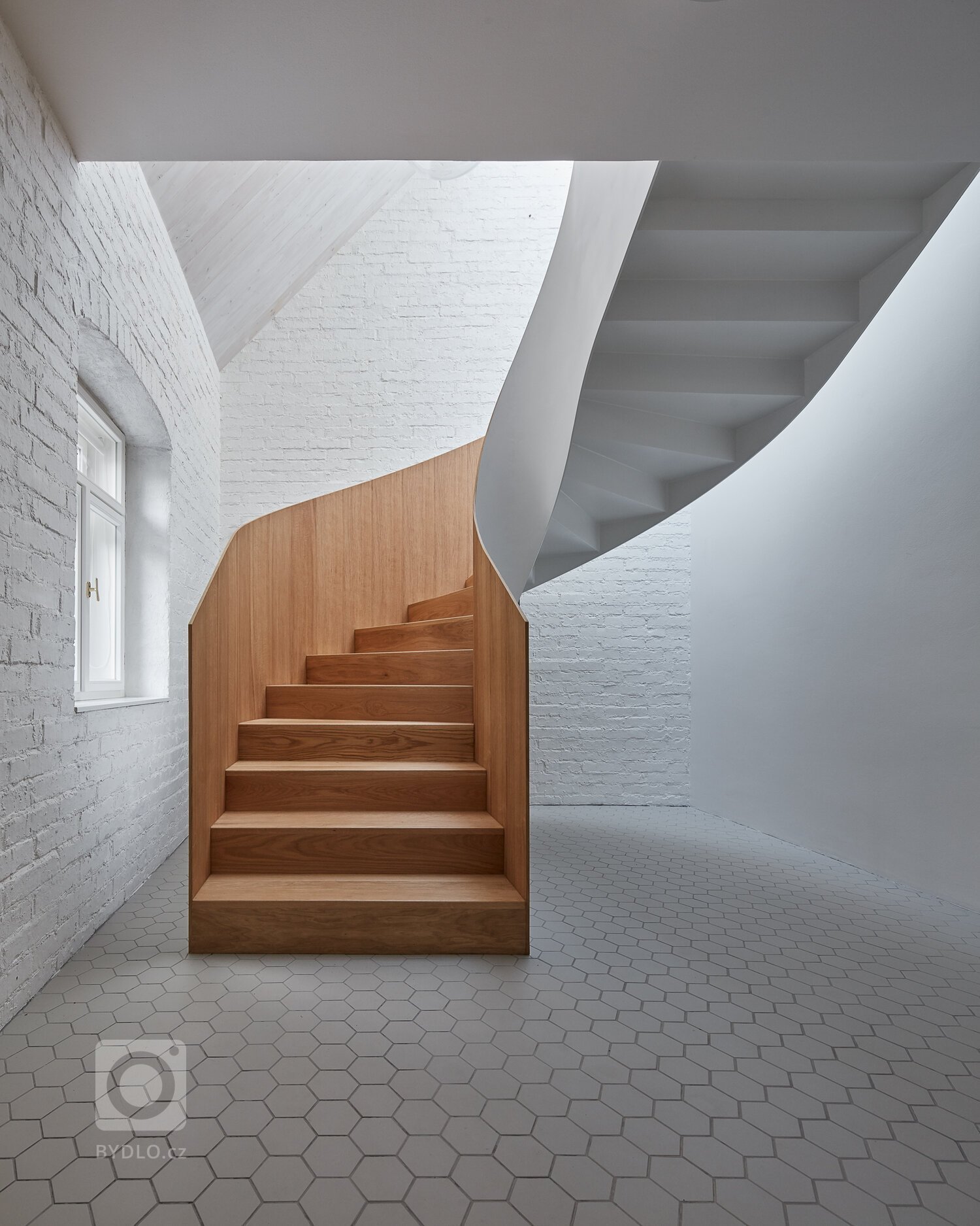 Úzká ulička, kde se zachoval ospalý charakter starých Jinonic, se rozšiřuje a vytváří malé náměstí se studnou.&nbsp;Dominoval zde opuštěný dům, tvořený…