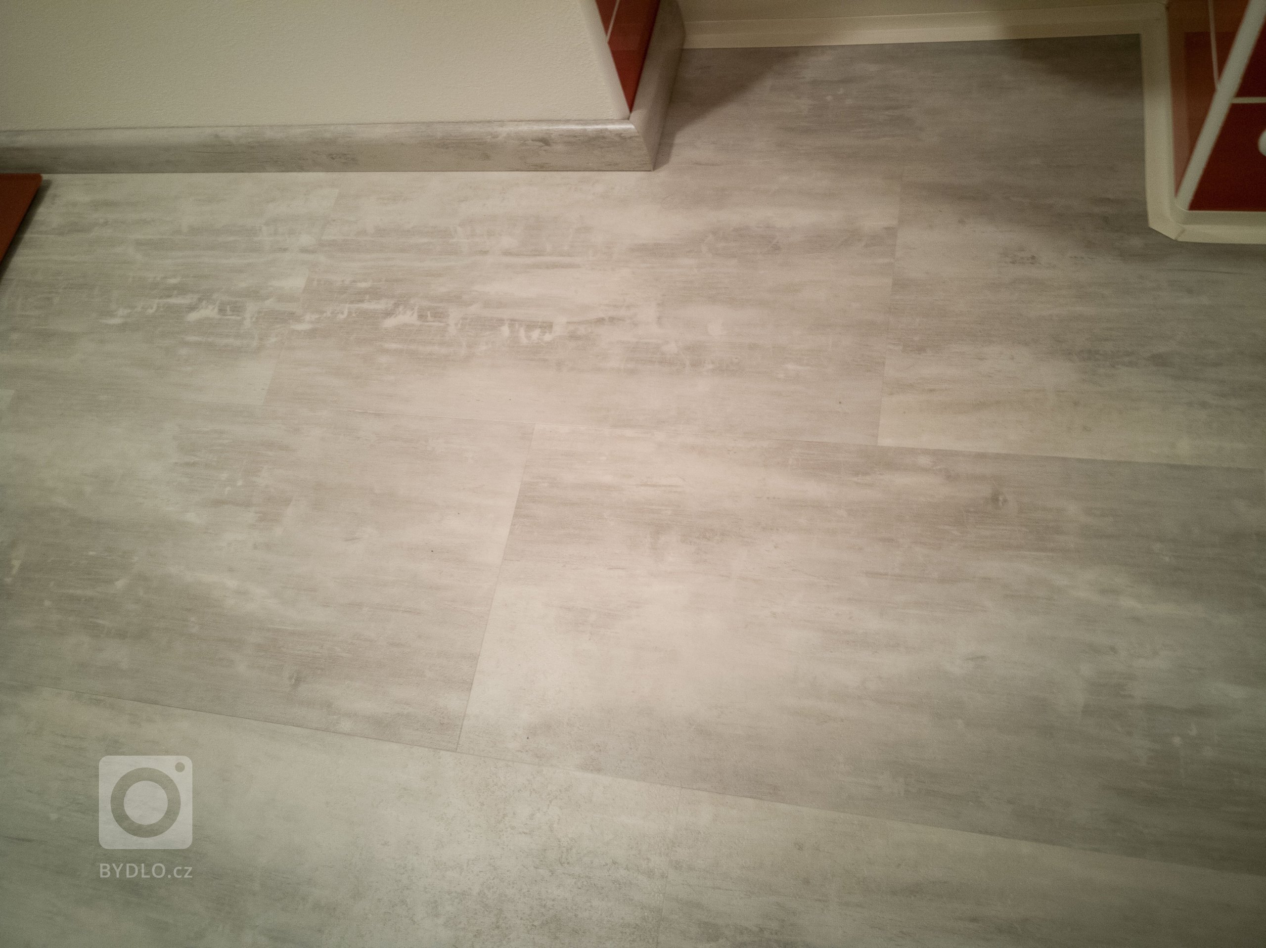 Další detail vinylové podlahy včetně soklové lišty se stejným dekorem jako podlaha