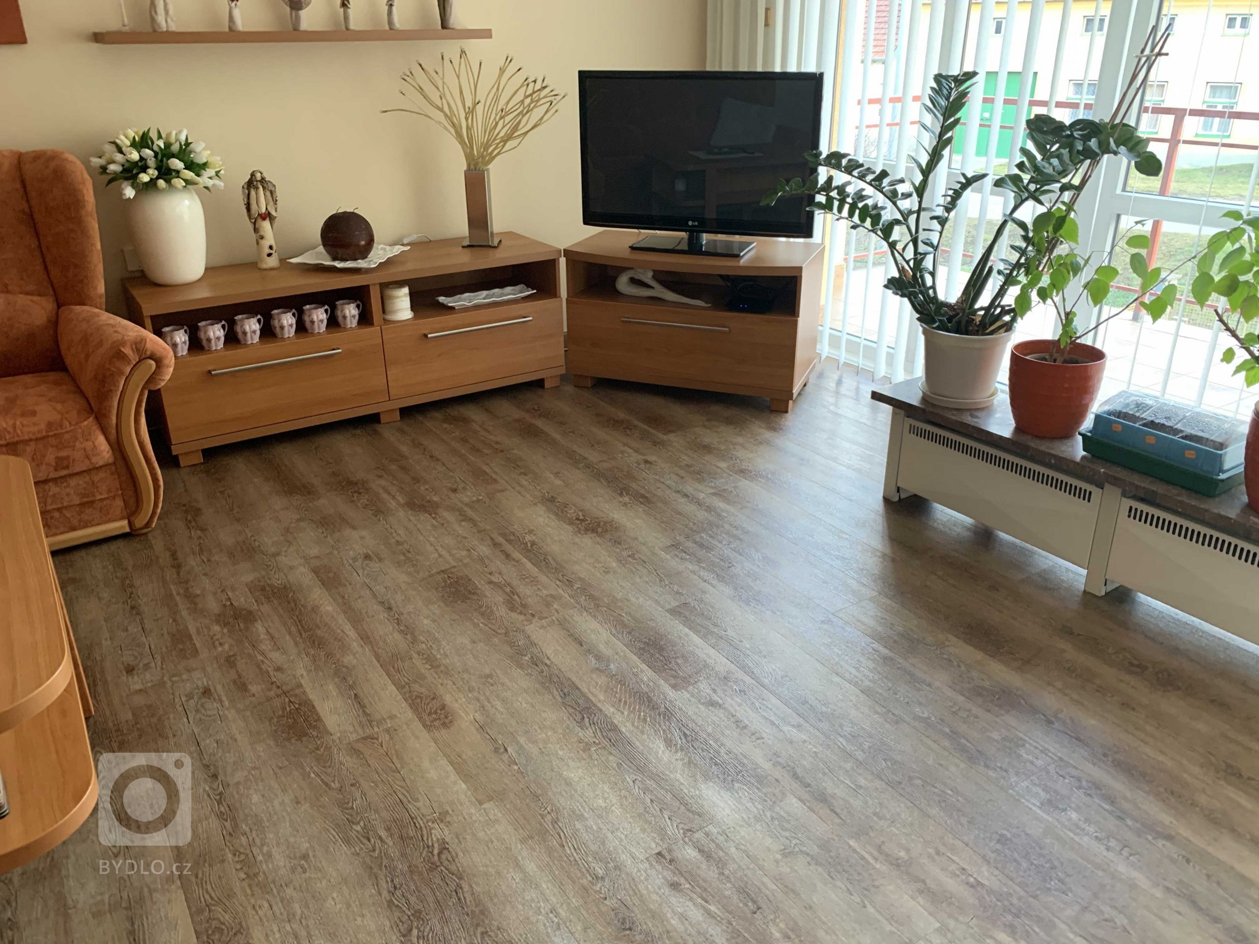 Obývací pokoj s novou vinylovou podlahou BUKOMA PREMIUM CLICK Dekor Dub Přírodní. Tato vinylová podlaha výborně ladí s interiérem, zpracováním je tato podlaha…