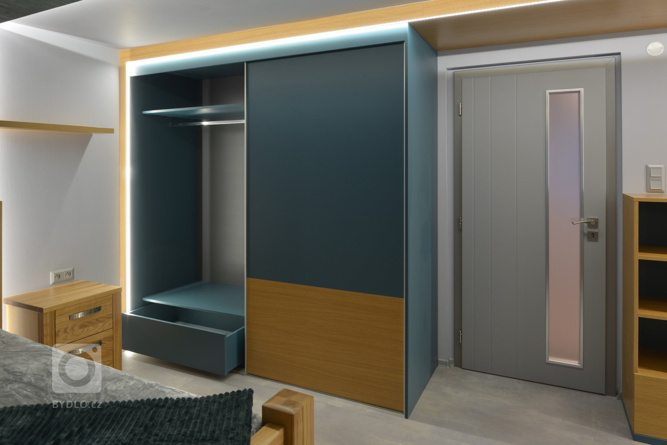 Skříně v kombinaci dub a petrolová s velkorysým úložným prostorem.