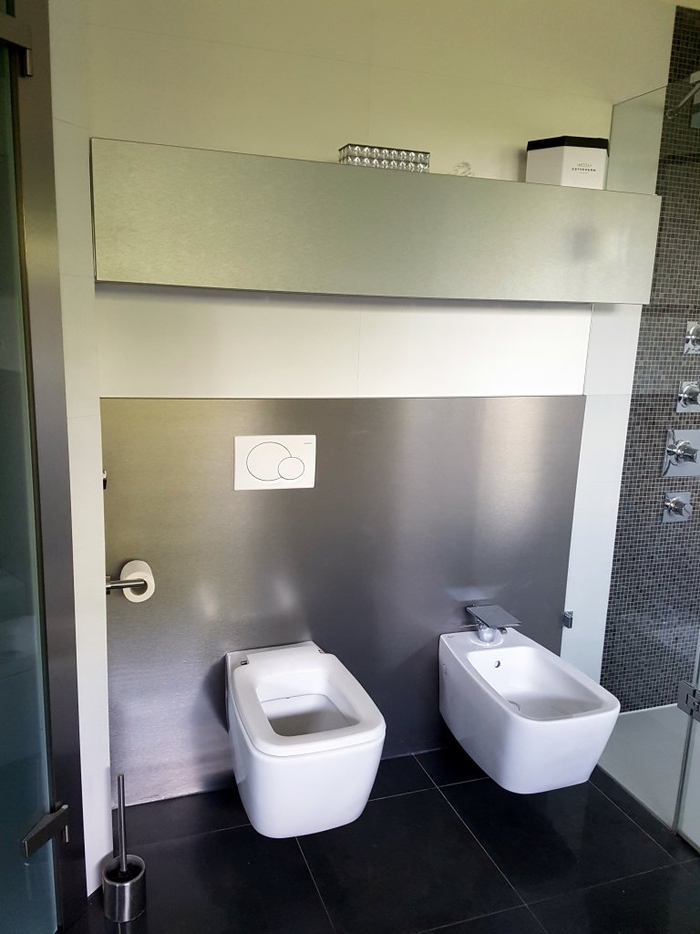 Jako pozadí pro WC a bidet byl použit stříbrný kartáčovaný kovolaminát. 