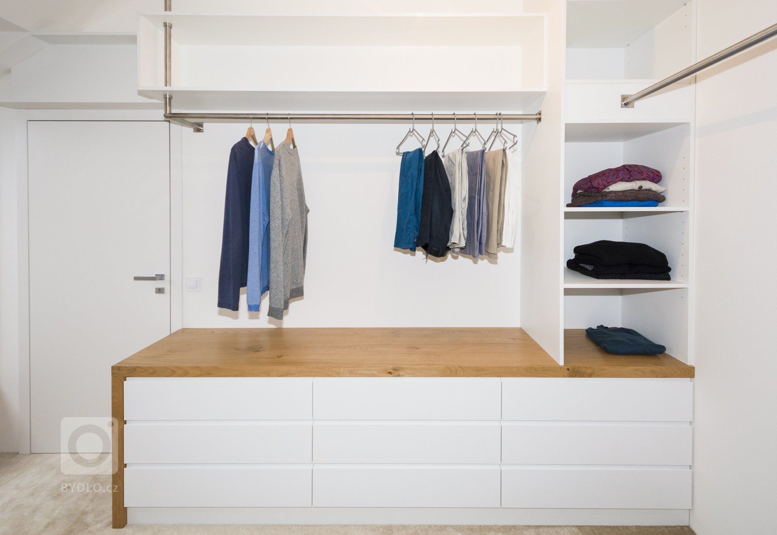 Šatna v&nbsp;podkrovním bytě se nachází mezi dvěma ložnicemi, které propojuje. Světlý pokoj poskytuje mnoho místa na ukládání oblečení a doplňků. Důraz při…