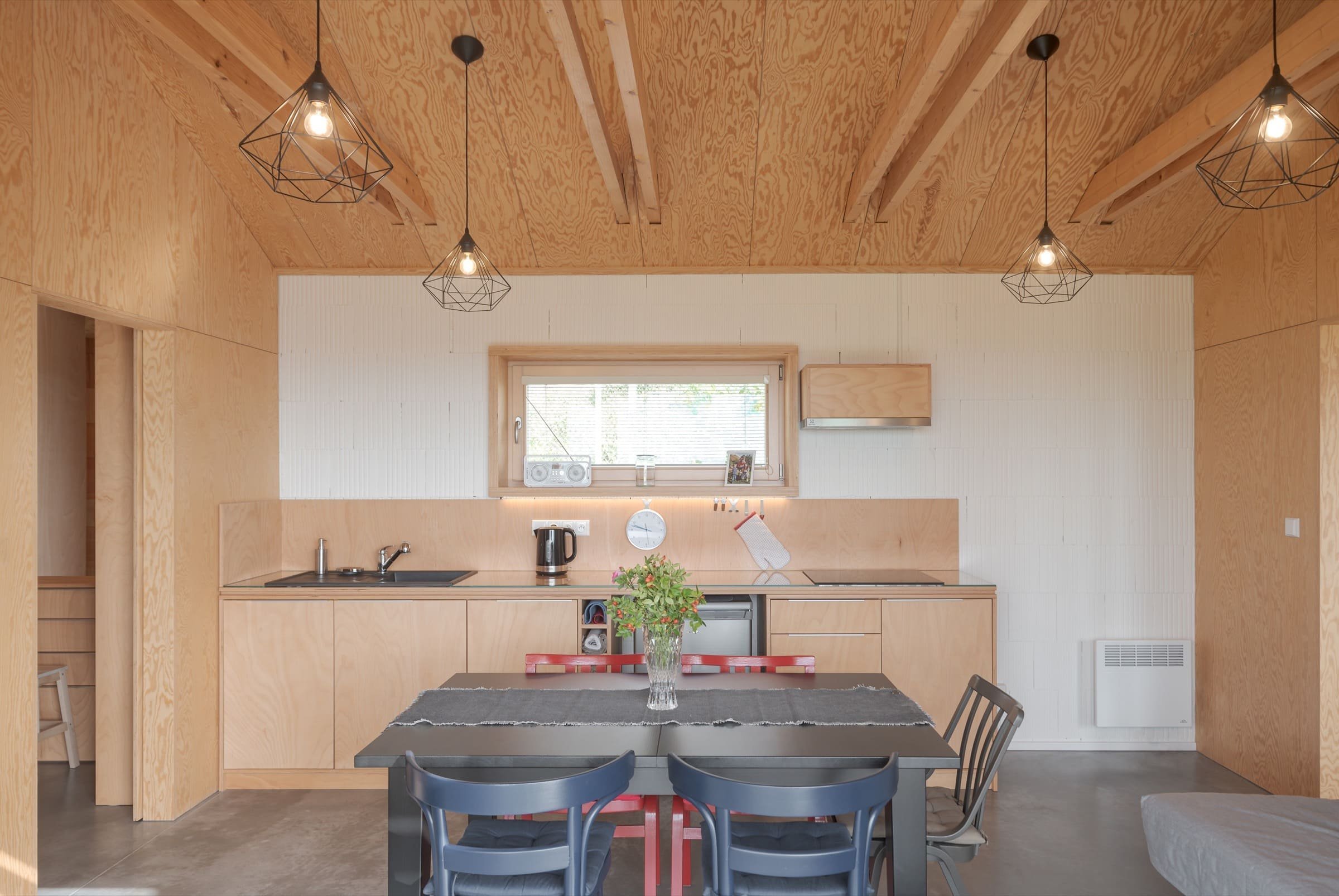 Překližka na obkladech a kuchyni dodává interiéru moderní, skoro až průmyslový charakter