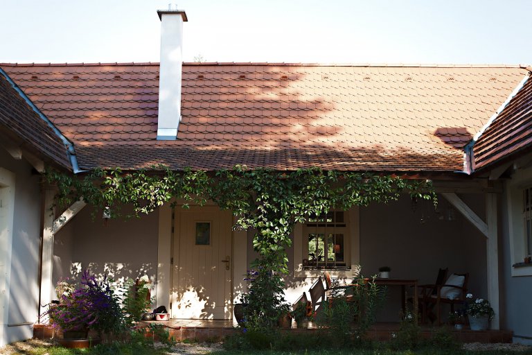 Přední posezení chráněné před deštěm a letním sluncem. Na podlaze je ruční cihlová dlažba.
