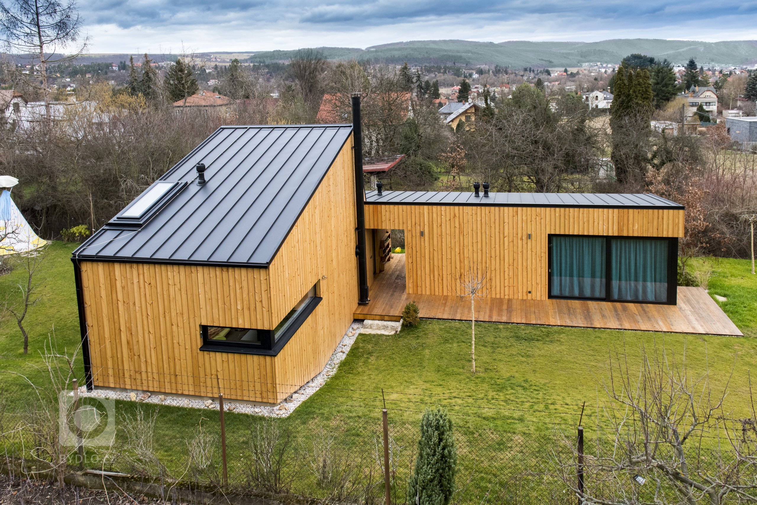 Nízkoenergetická dřevostavba ve tvaru písmene L je umístěna tak, aby měla co největší přísun slunečního světla. Dům se skládá ze dvou objektů s rozdílnými…