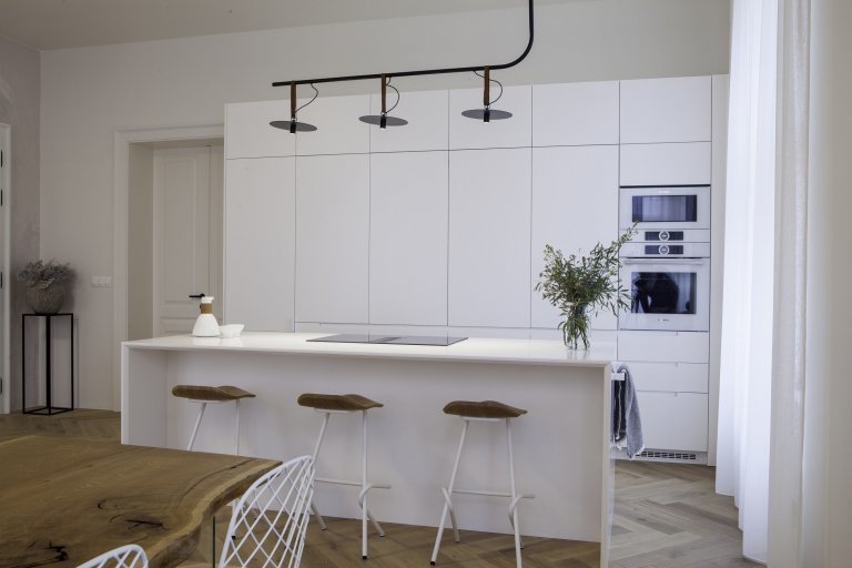 Kuchyňská linka s&nbsp;velkorysým ostrůvkem z materiálu Corian. Netradičním prvkem kuchyně je uzavíratelná část linky, díky které bude kuchyň vypadat uklizeně…