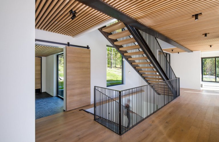 Venkovský dům na svahu obklopený lesem