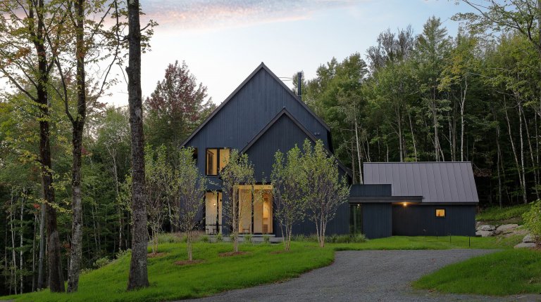 Venkovský dům na svahu obklopený lesem