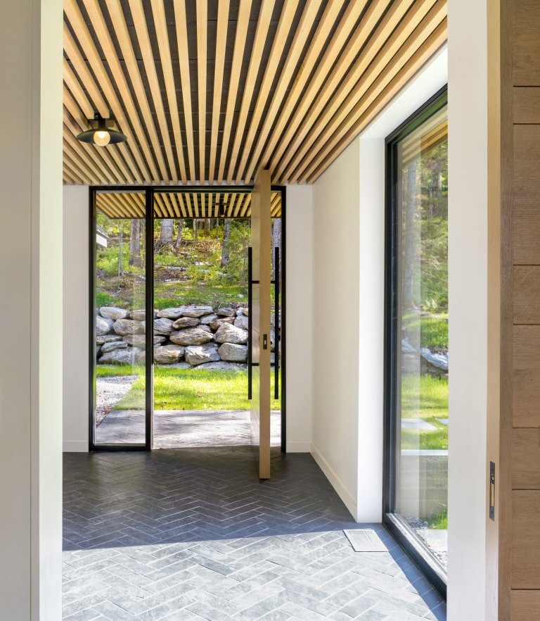 Venkovský dům na svahu obklopený lesem