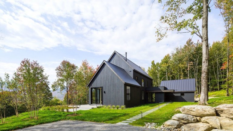 Venkovský dům na svahu obklopený lesem