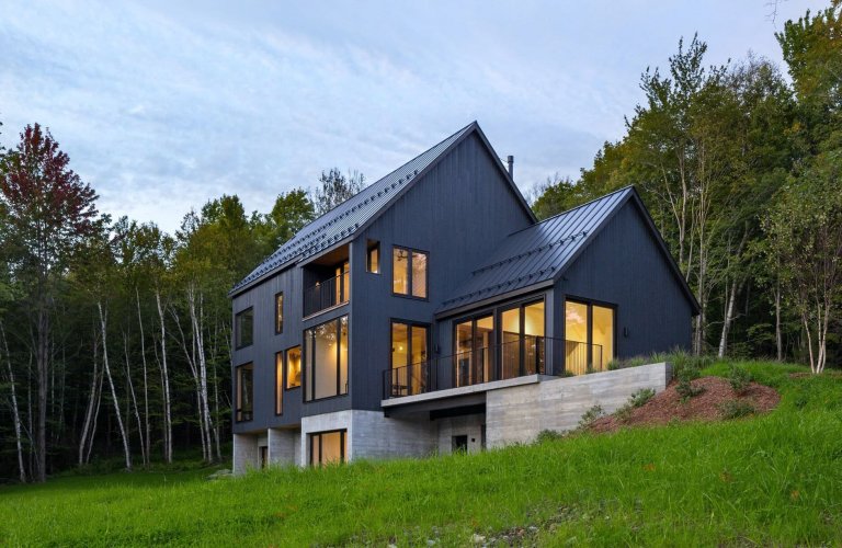 Venkovský dům na svahu obklopený lesem