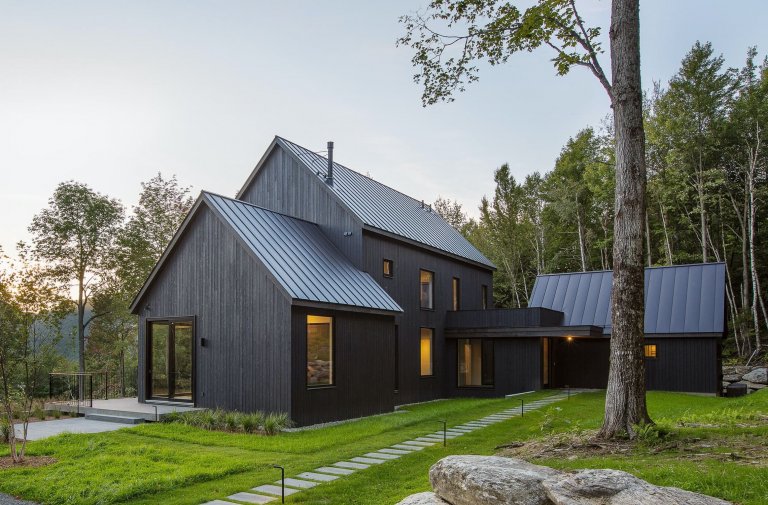 Venkovský dům na svahu obklopený lesem