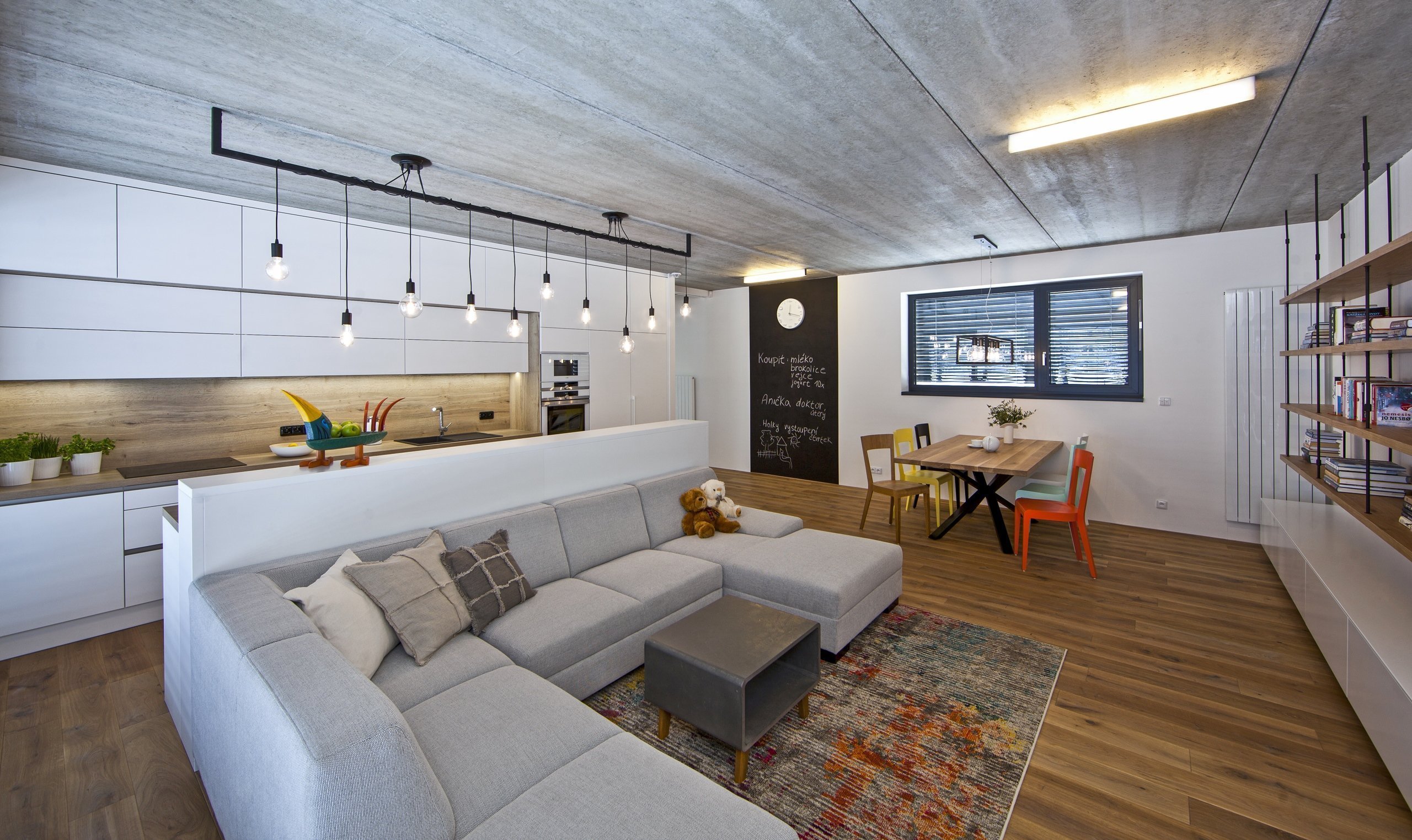 V celém domě se prolínají přírodní materiály s černými kovovými prvky a detaily s bílými stěnami a dveřmi. Industriální ráz podtrhují přiznané betonové stropy…