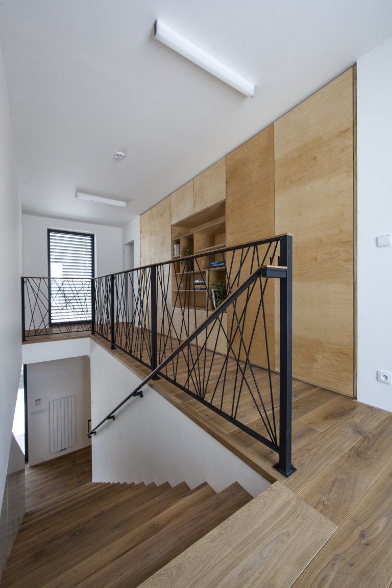 V celém domě se prolínají přírodní materiály s černými kovovými prvky a detaily s bílými stěnami a dveřmi. Industriální ráz podtrhují přiznané betonové stropy…