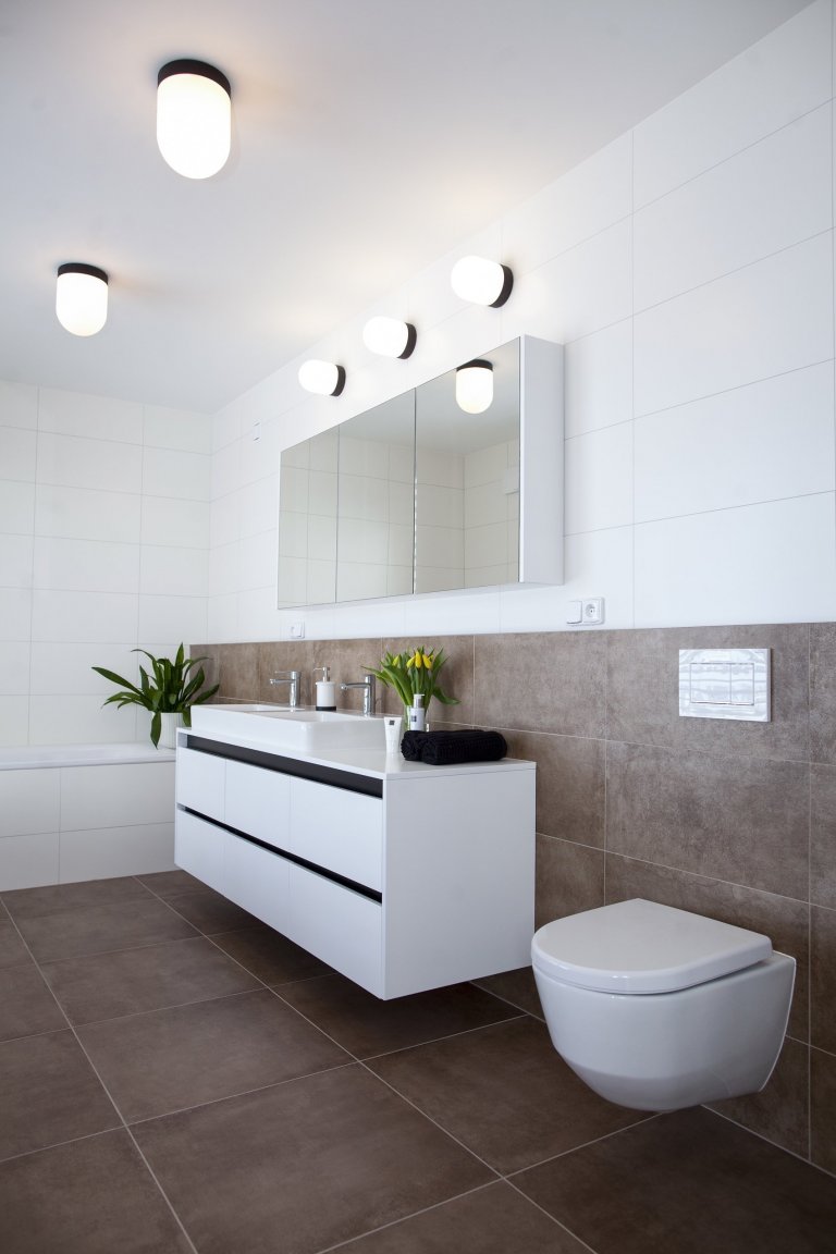 V celém domě se prolínají přírodní materiály s černými kovovými prvky a detaily s bílými stěnami a dveřmi. Industriální ráz podtrhují přiznané betonové stropy…