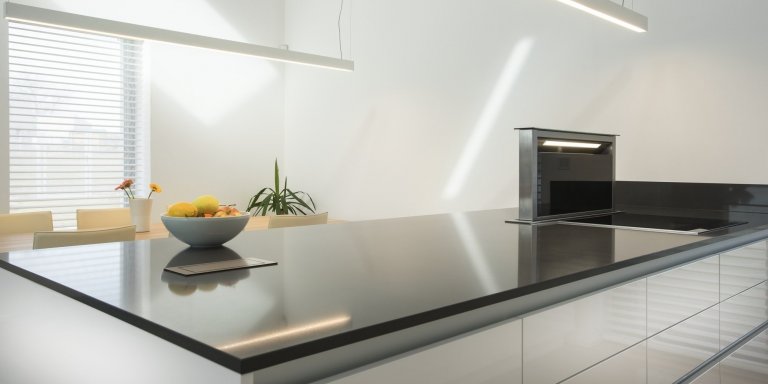 Kuchyň BEECK KÜCHEN, rodinný dům. Provedení - Colora lesk bílá, pracovní deska Technistone Crystal Anthracit. Kuchyň je vybavena spotřebiči Siemens. Stůl a…