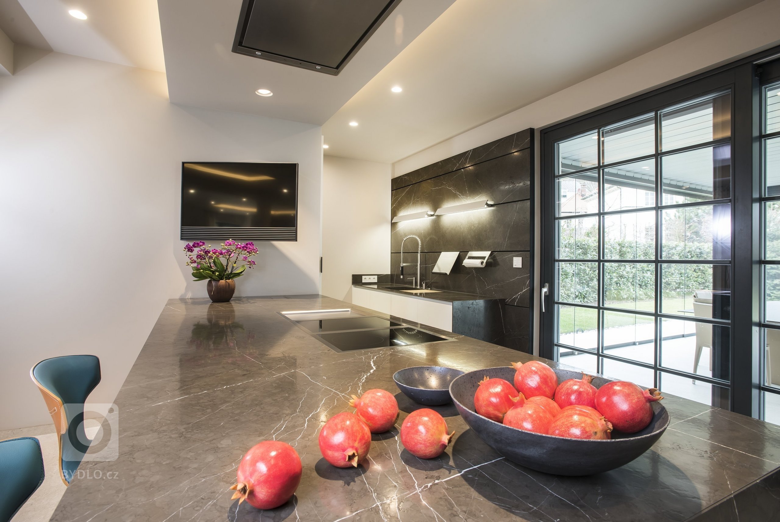 Kuchyň EGGERSMANN UNIQUE, rodinný dům. Provedení je masivní kámen Graphit Brown Leather na ostrůvku v&nbsp;kombinaci s Paso supermatt lotus white a broušeným…