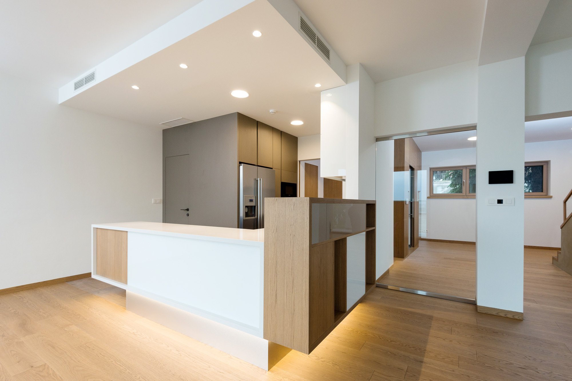 Elegantný a moderný interiér rodinného domu realizovaný pomocou prírodných materiálov v kombinácii s umelým kameňom a lamino povrchom.
