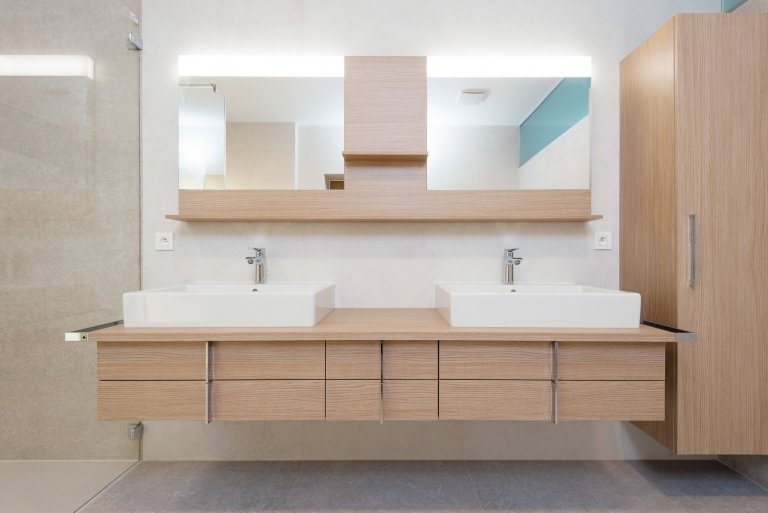 Elegantný a moderný interiér rodinného domu realizovaný pomocou prírodných materiálov v kombinácii s umelým kameňom a lamino povrchom.
