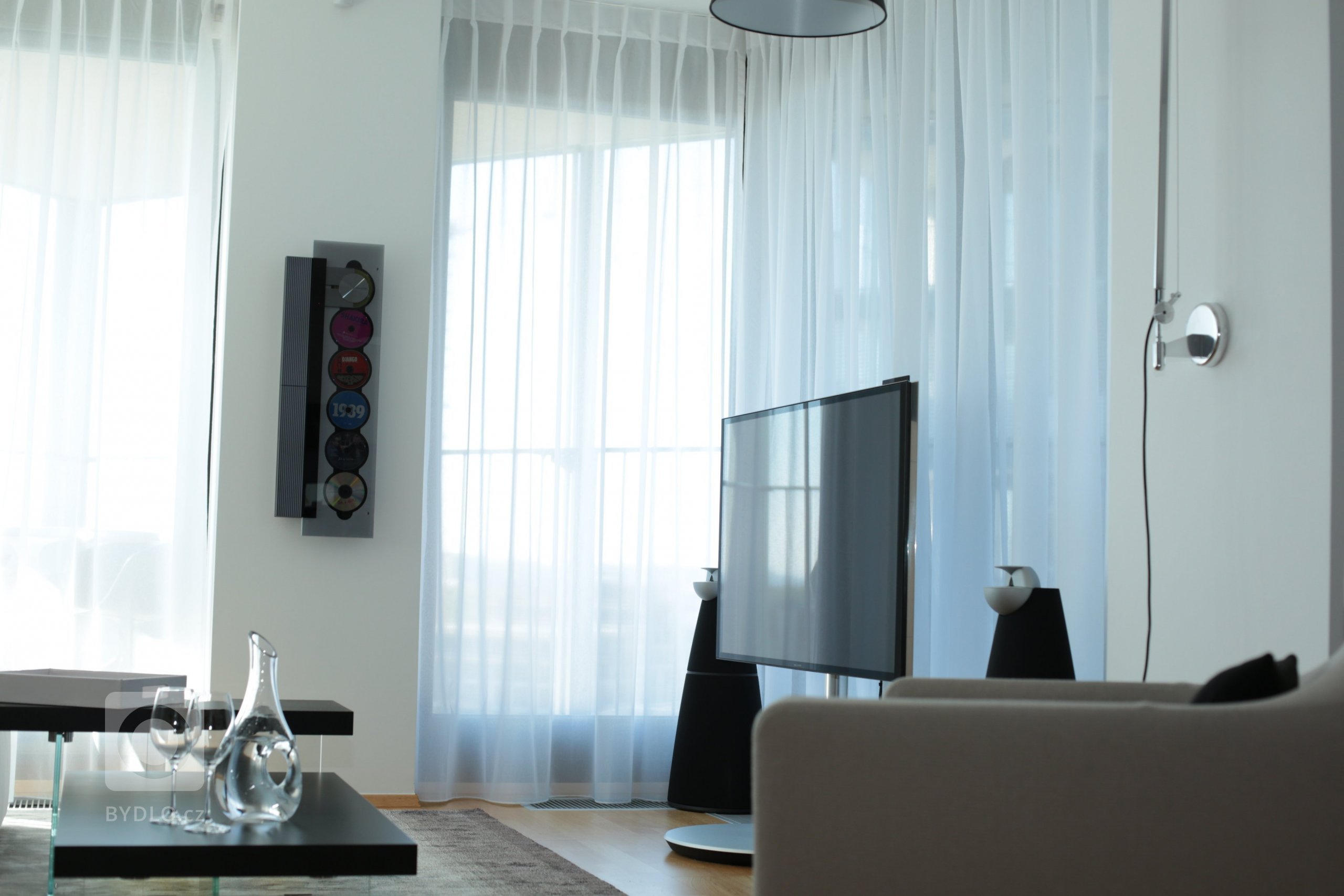 CD přehrávač jako nástěnná dekorace a místo obývací stěny jen televize a hlavně krásný výhled na Prahu.