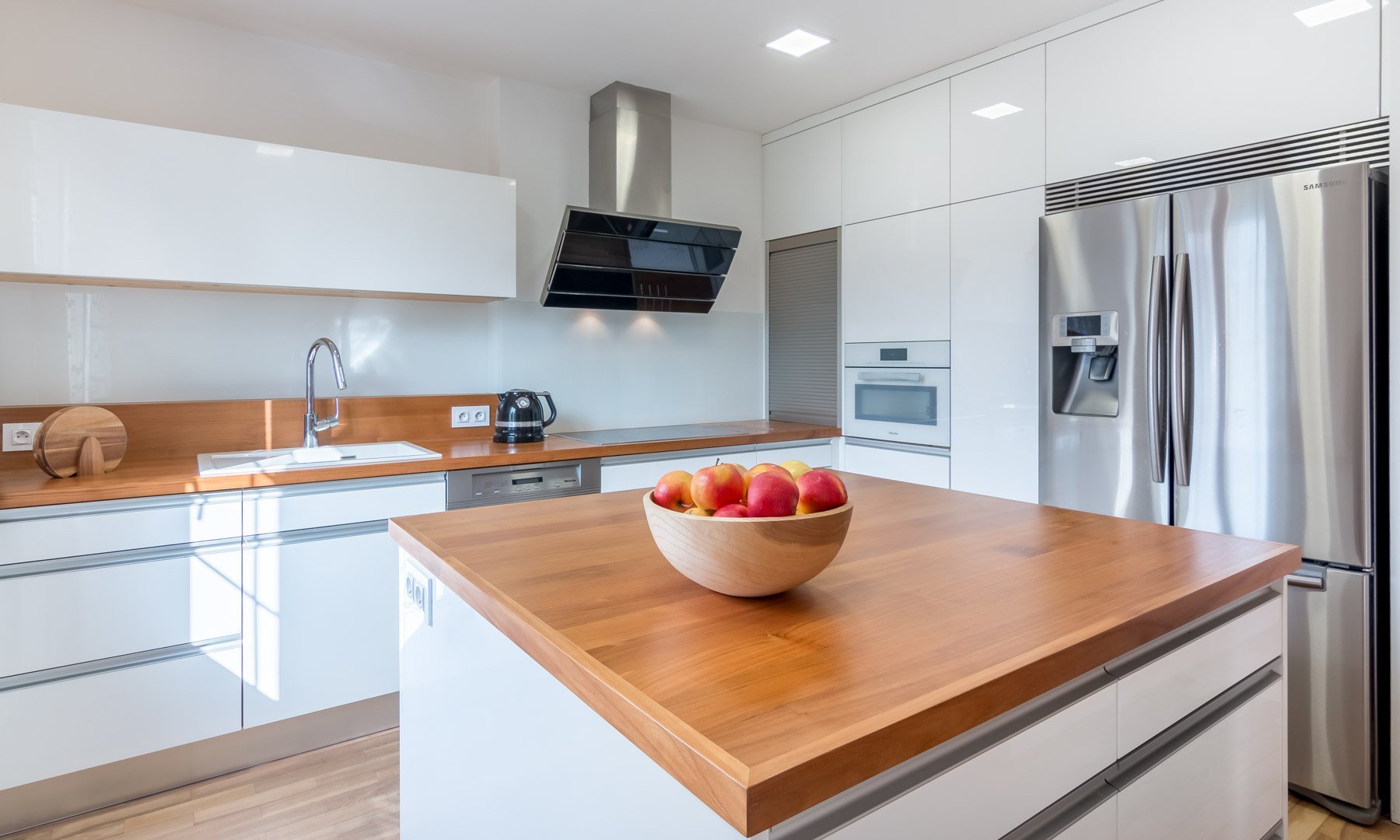Luxusní minimalistická kuchyň plná čistých linií a volného prostoru! Kombinace zářivě bílých skříněk a krásně zpracovaného smrkového dřeva láká na první pohled…