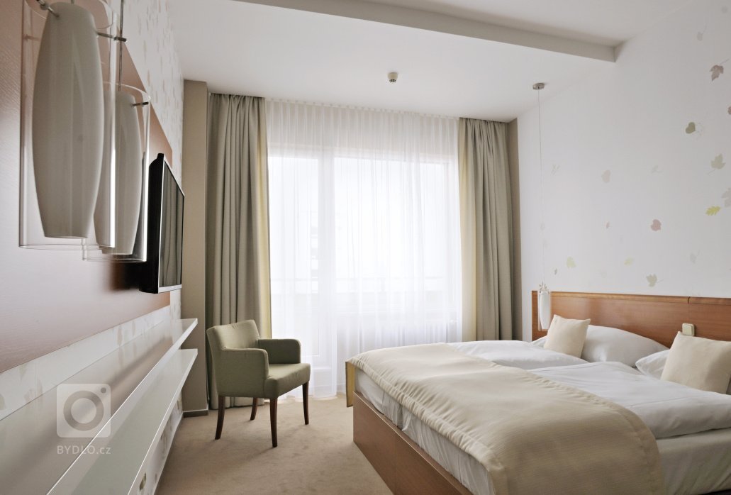 Proměna hotelového pokoje s částečným využitím stávajícího mobiliáře. Barevné ladění&nbsp;v podzimních tónech s odpovídajícím dekorem obrazové tapety přináší…