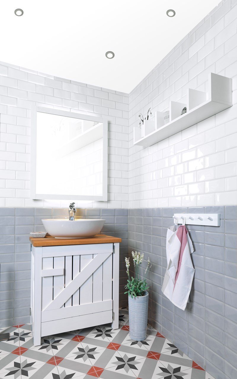 Retro koupelna s obdélníkovými obklady a dlažbou s klasickým historickým vzorem.