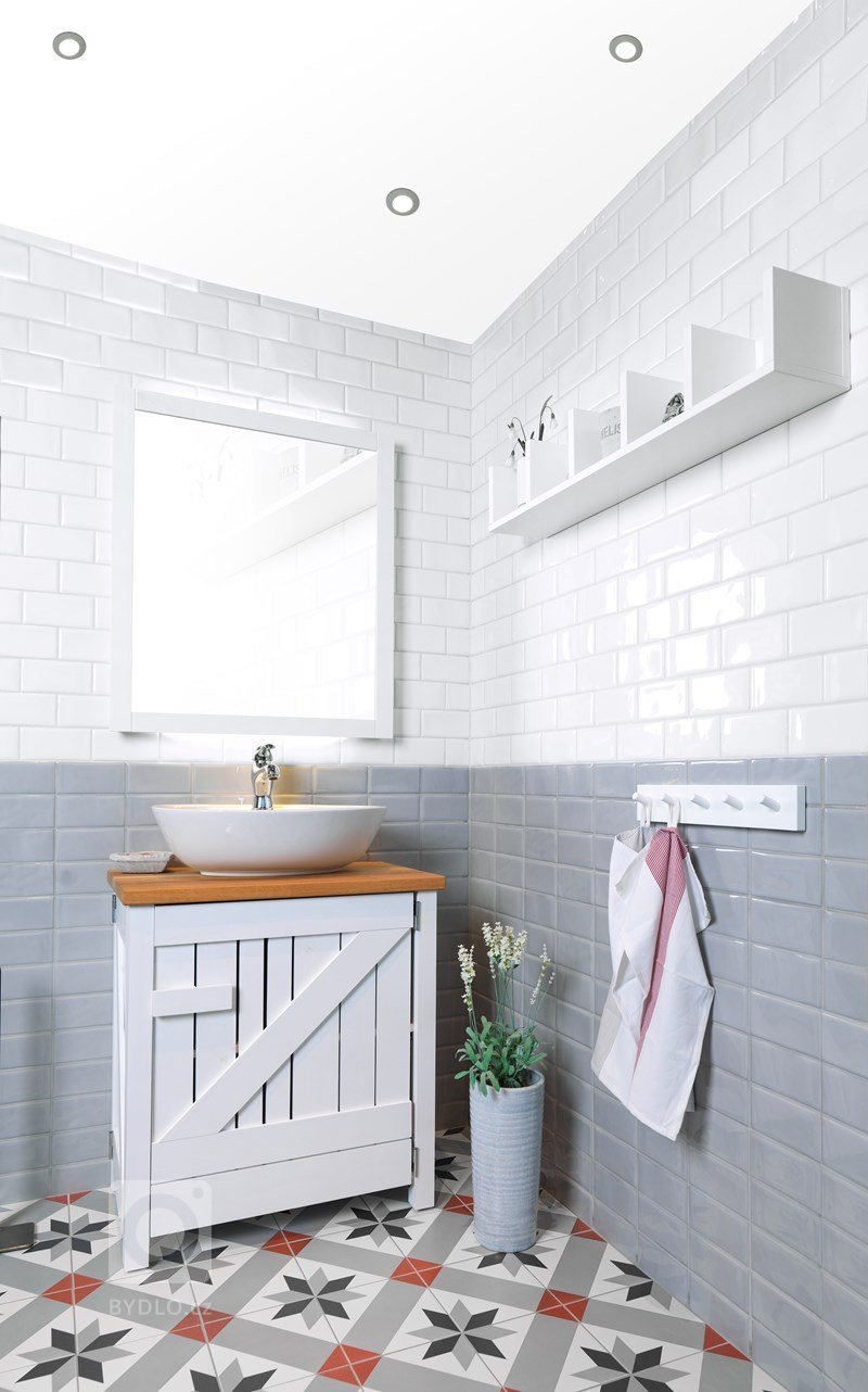 Retro koupelna s obdélníkovými obklady a dlažbou s klasickým historickým vzorem.